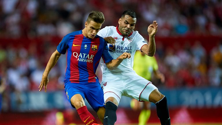 Denis Suarez of Barcelona (L) is challenged by Gabriel Mercado of Sevilla during the Super Cup game