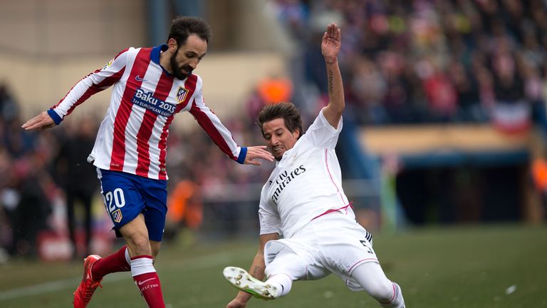 Juan Francisco Torres alias Juanfran (L) of Atletico de Madrid competes for the ball with Fabio Coentrao (R) of Real Madrid CF