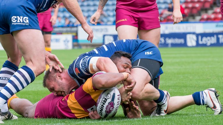 Huddersfield's Ukuma Ta'ai touches down for a try as Featherstone's Darrell Griffin attempts to hold him up.