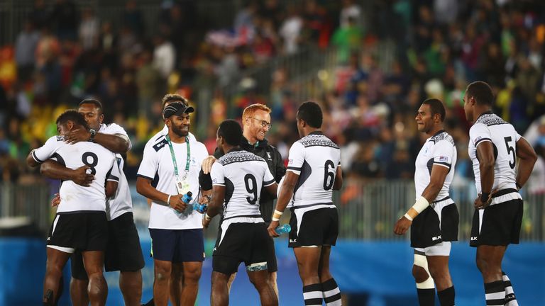 Fiji head coach Ben Ryan celebrates with players as they win gold 