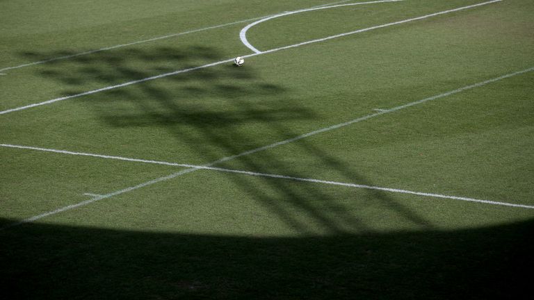 The shadow of a floodlight on a football pitch 