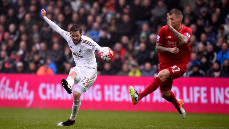 Swansea's Gylfi Sigurdsson gets in a shot at goal despite the attentions of Liverpool's Martin Skrtel 