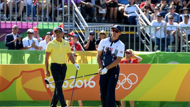 RIO DE JANEIRO, BRAZIL - AUGUST 14:  Justin Rose of Great Britain plays his shot from the first tee as Henrik Stenson of Sweden looks on during the final r