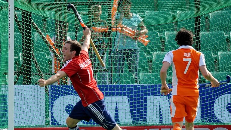 English hockey player Alastair Brogdon (L) runs past the Netherlands' Wouter Jolie (R) after scoring a goal