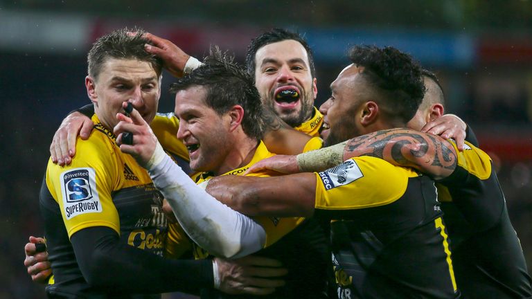 Cory Jane of the Hurricanes celebrates a try with team-mates
