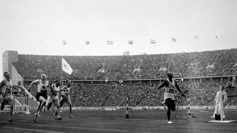Jesse Owens (1913 - 1980) of the USA (right) crosses the finishing line to win the 100 metres at the 1936 Olympics in Berlin. He won three other gold medal