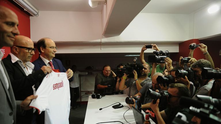 Sevilla's new Argentinian coach Jorge Sampaoli (2nd L) holds a jersey with his name between Sevilla's President Jose Castro (3rd L) and technical director 