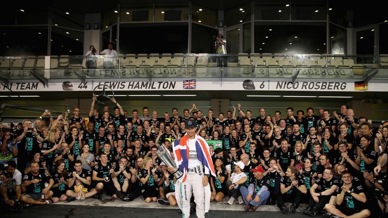 ABU DHABI, UNITED ARAB EMIRATES - NOVEMBER 23:  Lewis Hamilton of Great Britain and Mercedes GP celebrates with his team after winning the World Championsh