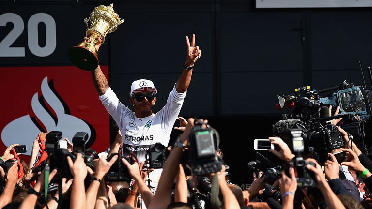 NORTHAMPTON, ENGLAND - JULY 06:  Lewis Hamilton of Great Britain and Mercedes GP his held aloft by his team mates as he holds the old British Grand Prix Tr