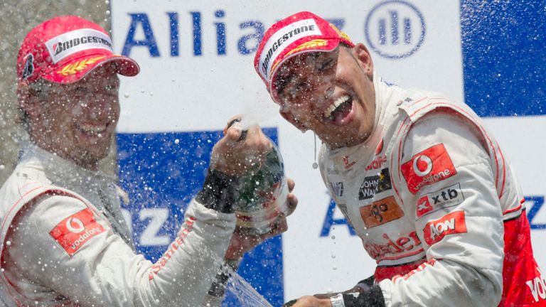 McLaren Mercedes driver Lewis Hamilton (R) of Britain and teammate McLaren Mercedes driver Jenson Button of Britain celebrate with champagne after winning 