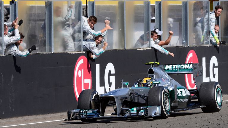 Mercedes'  British driver Lewis Hamilton celebrates winning as he passes teammates at the Hungaroring circuit in Budapest on July 28, 2013 after the Hungar
