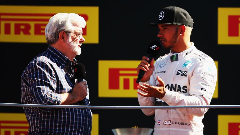 MONZA, ITALY - SEPTEMBER 06:  Lewis Hamilton of Great Britain and Mercedes GP speaks with film director George Lucas on the podium after winning the Formul