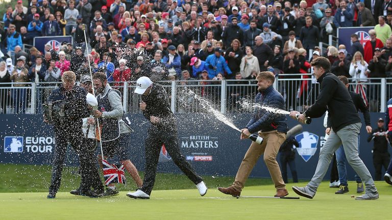 WOBURN, ENGLAND - OCTOBER 11:  Matthew Fitzpatrick of England is sprayed with sparkling wine by friends on the 18th green after winning the British Masters
