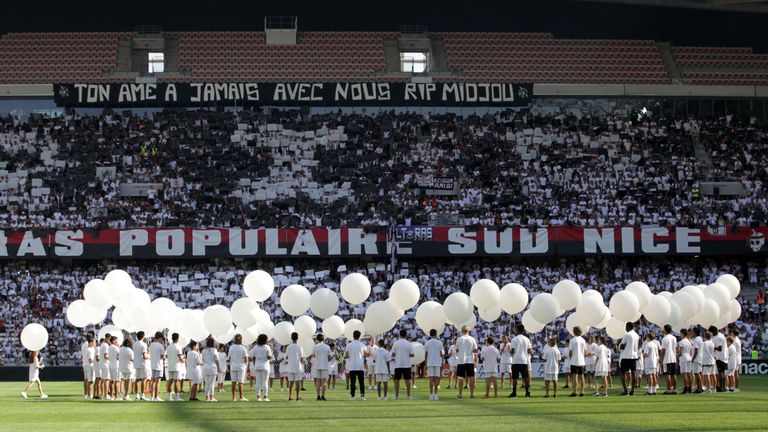 People held white ballons in the middle of the pitch in tribute to the victims of the Bastille day attack in Nice