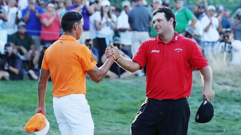 Patrick Reed (R) greets Rickie Fowler on the 18th green after Reed won The Barclays