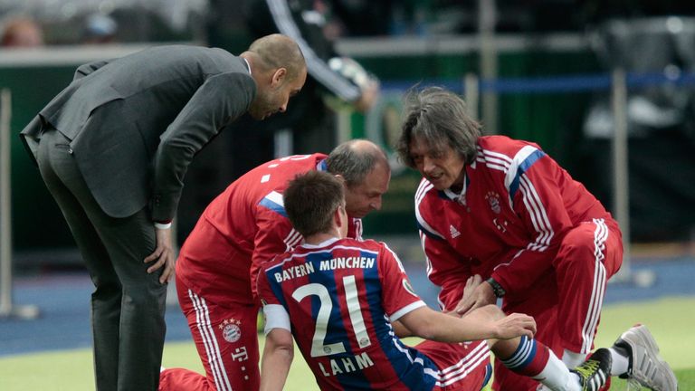 Hans-Wilhelm Muller-Wohlfahrt (right) treats Philipp Lahm as Pep Guardiola watches on