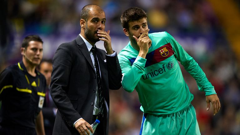 VALENCIA, SPAIN - MAY 11:  Head Coach Josep Guardiola (L) of Barcelona gives instructions to Gerard Pique during the La Liga match between Levante UD and B