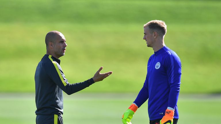 Manchester City manager Pep Guardiola talks to goalkeeper Joe Hart during a training session at the City Football Academy, Manchester.