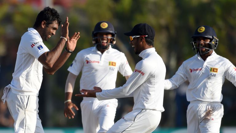 Sri Lankan cricketer Dilruwan Perera (L) celebrates with teammates after he dismissed Australian batsman Usman Khawaja  during the second day of the second