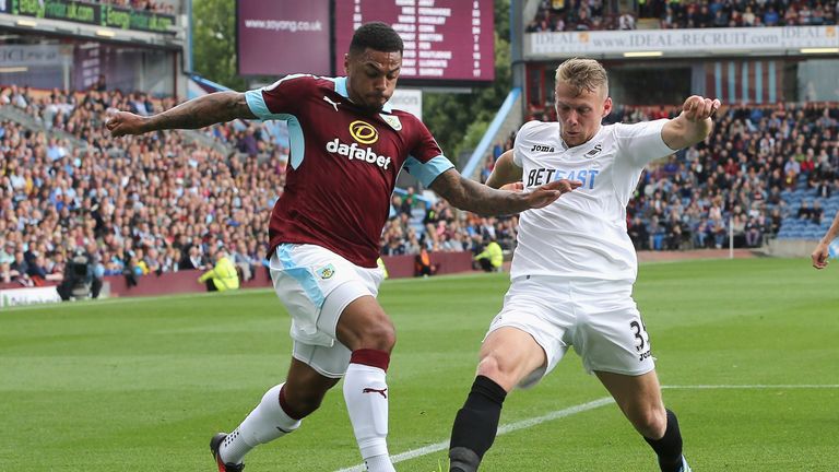 BURNLEY, ENGLAND - AUGUST 13: Andre Gray of Burnley takes on Stephen Kingsley of Swansea City during the Premier League match between Burnley and Swansea C