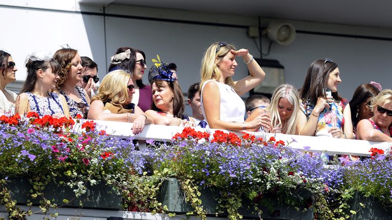 Racegoers watch the action during Betfred Rose Of Lancaster Stakes at Haydock Park Racecourse.