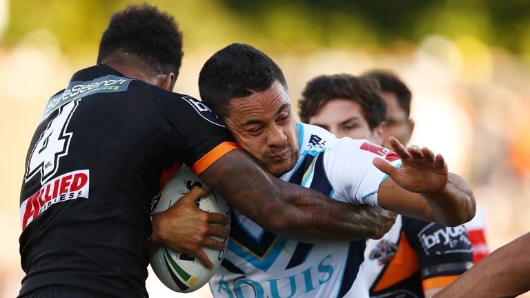 Jarryd Hayne is tackled by Kevin Naiqama of Wests Tigers