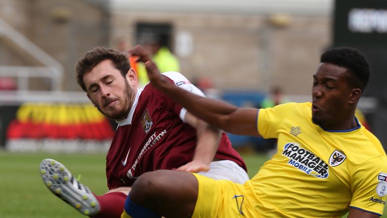 Jak McCourt of Northampotn Town challenges for the ball with Dominic Poleon of AFC Wimbledon 