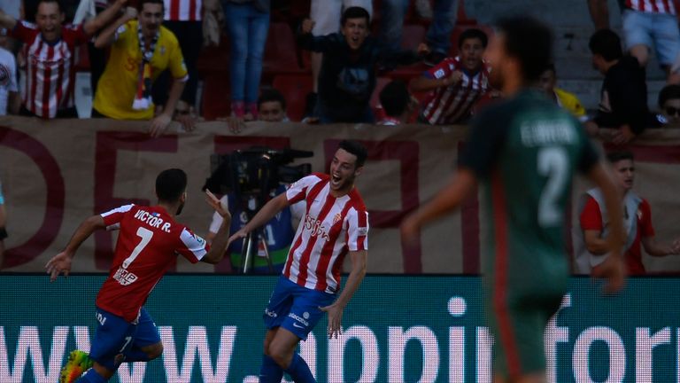 Sporting Gijon's forward Victor Rodriguez (L) celebrates with teammate forward Burgui Franco after scoring a goal during the Spanish league football match 
