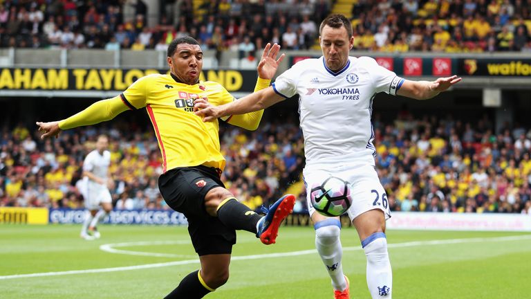 Troy Deeney of Watford stretches to get to the ball before John Terry