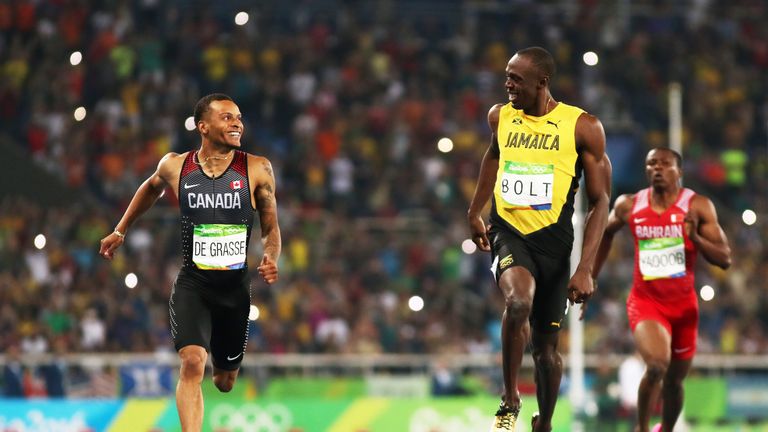 Bolt smiles across at Canada's Andre de Grasse in the 200m semi-final