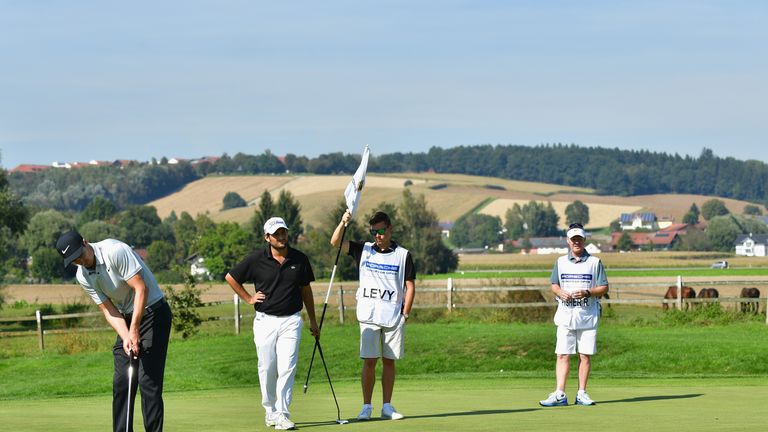 PASSAU, GERMANY - SEPTEMBER 25: Alexander Levy of France watches on as Ross Fisher of England puts during the final round of the Porsche European Open at G