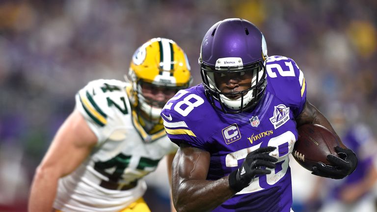 Adrian Peterson (L) carries the ball with Jake Ryan in pursuit