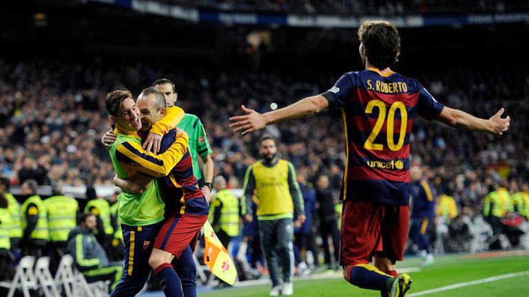 Andres Iniesta runs to celebrate with Lionel Messi after scoring against Real Madrid