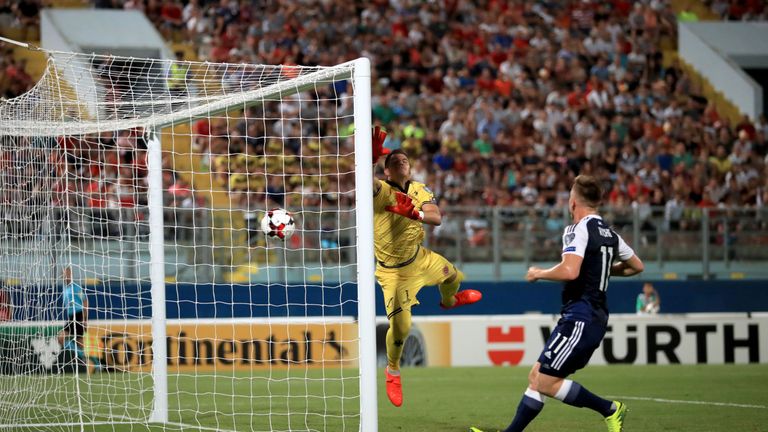 Malta goalkeeper Andrew Hogg dives in vain as the cross from Scotland's Robert Snodgrass goes directly into the goal 