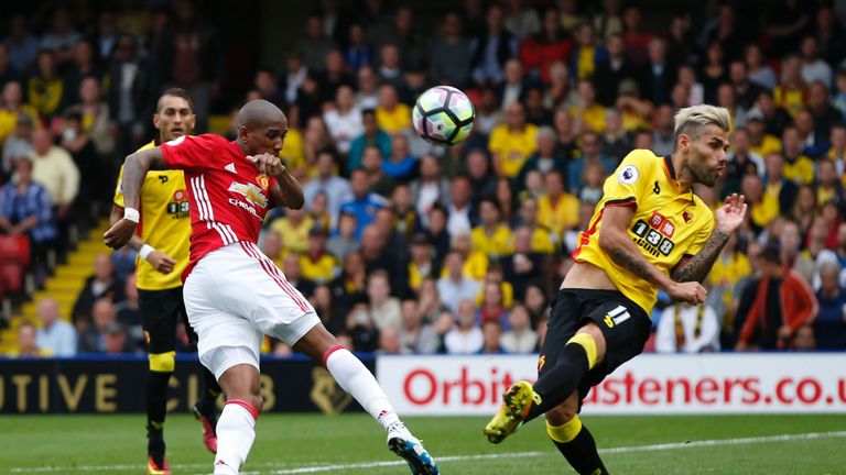 Manchester United's Ashley Young (L) has a shot blocked by Watford's midfielder Valon Behrami