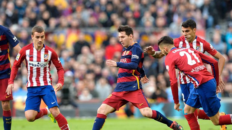 Lionel Messi (C) vies for possession with Antoine Griezmann (L) and Augusto Fernandez (R) at the Camp Nou
