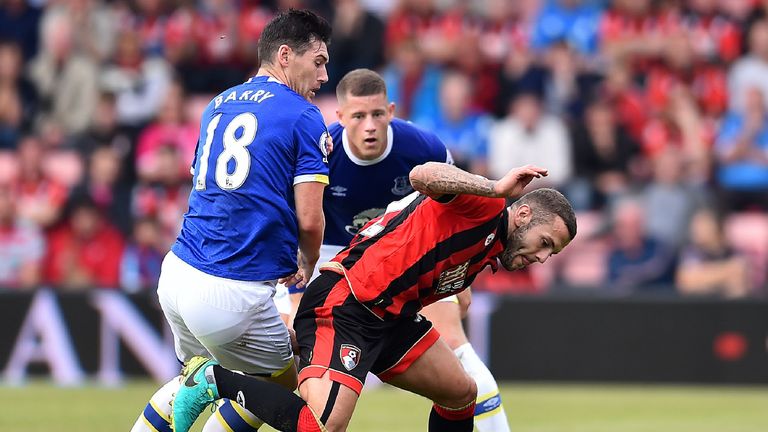 Jack Wilshere (R) vies for possession with Gareth Barry