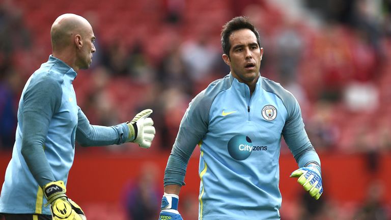 Claudio Bravo (R) warms up tam-mate Willy Caballero ahead of the Manchester derby