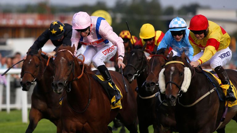 Cotai Glory ridden by George Baker (left) leads the field home to win the Dubai International Airport World Trophy Stakes at Newbury