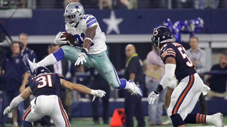 ARLINGTON, TX - SEPTEMBER 25:  Ezekiel Elliott #21 of the Dallas Cowboys jumps over the tackle attempt by Chris Prosinski #31 of the Chicago Bears in the f