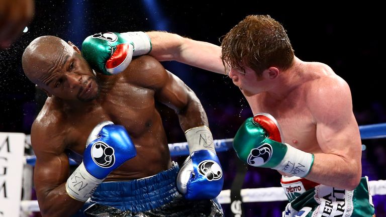 LAS VEGAS, NV - SEPTEMBER 14:  (R-L) Canelo Alvarez throws a right at Floyd Mayweather Jr. during their WBC/WBA 154-pound title fight at the MGM Grand Gard