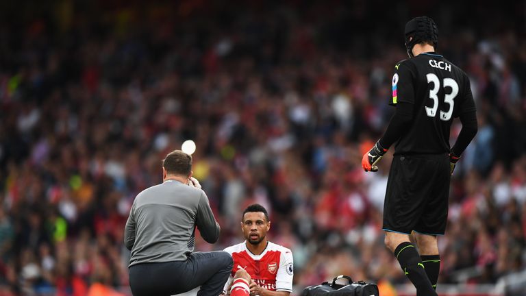 Francis Coquelin of Arsenal (C) gets treatment from the Arsenal medical team after he was injured against Chelsea