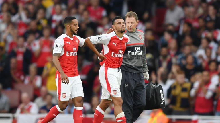 Theo Walcott of Arsenal (L) pats Francis Coquelin of Arsneal (C) on the back after he gets taken off injured 