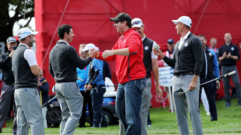 USA fan David Johnson is congratulated by Rory McIlroy after making the putt