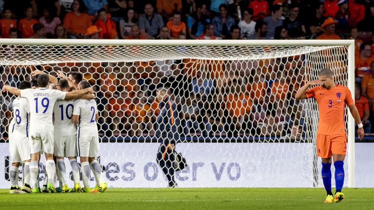 Greece's players (L) celebrate after winning a friendly football match against Netherlands at the Philips Stadium in Eindhoven, on September 1, 2016. / AFP