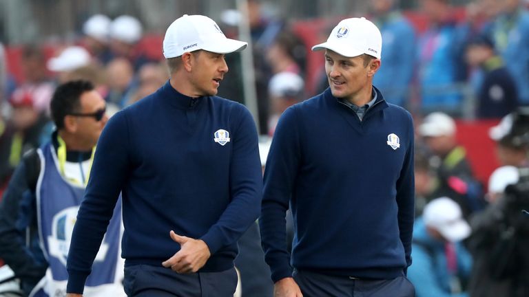 Henrik Stenson and Justin Rose of Europe walk off the first tee 