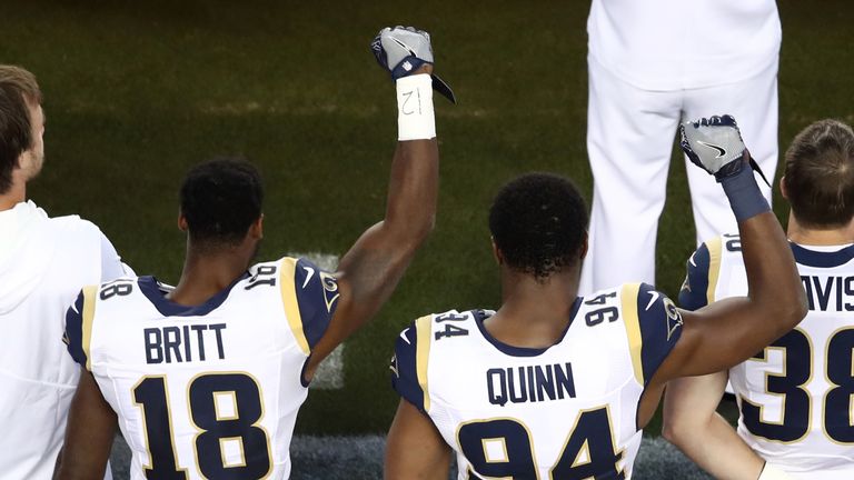 LA Rams' Kenny Britt and Robert Quinn raise their fists during the anthem