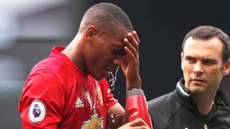 Anthony Martial walks off the pitch with a member of the Manchester United medical team