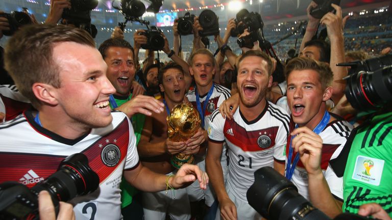 Mesut Ozil of Germany holds the trophy while Kevin Grosskreutz,  Shkodran Mustafi and Erik Durm celebrate after the 2014 World Cup final against Argentina.