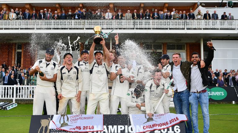 Middlesex players celebrate with the County Championship trophy